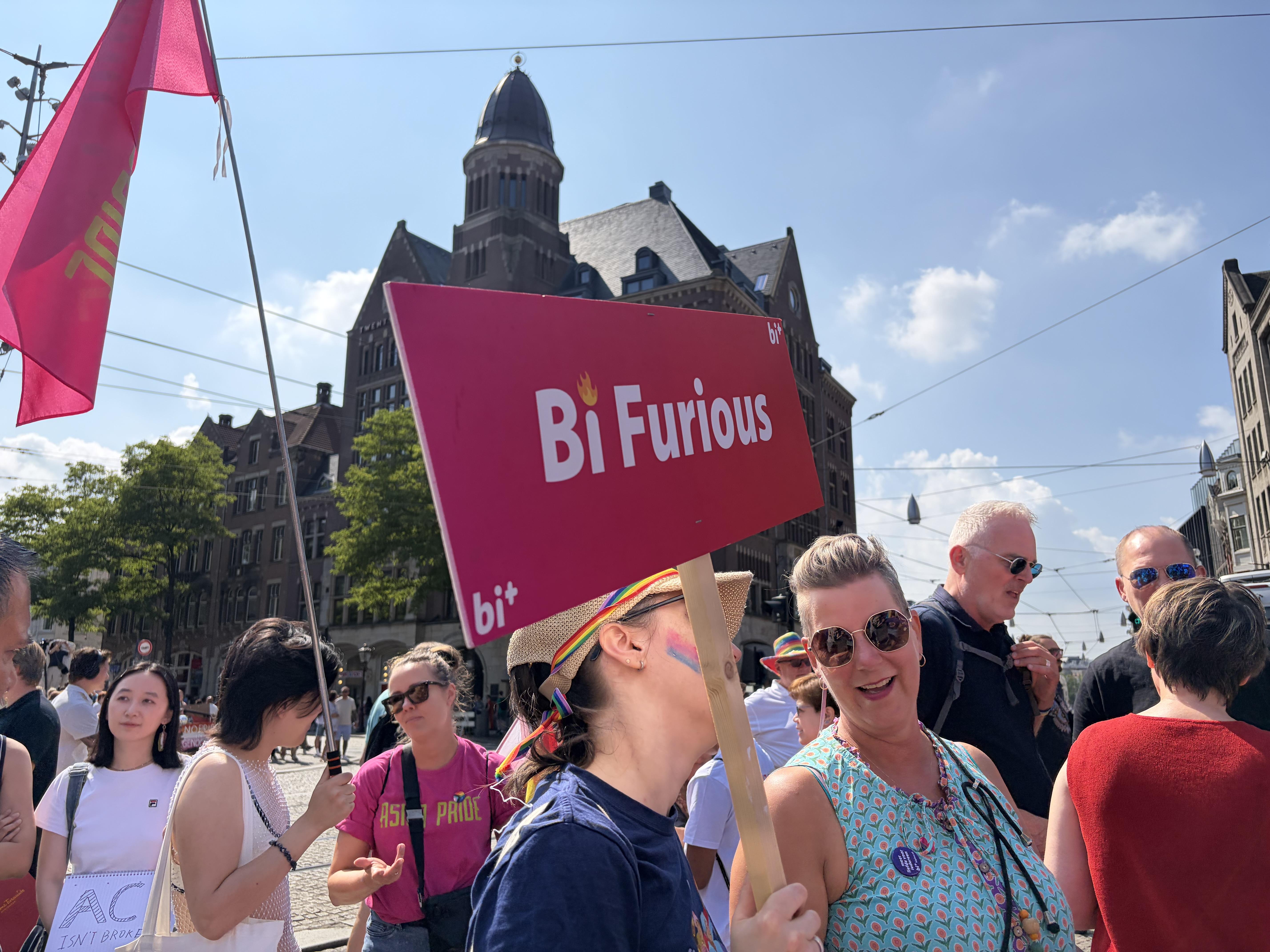Bi Furious sign with folks in Dams Square Amsterdam