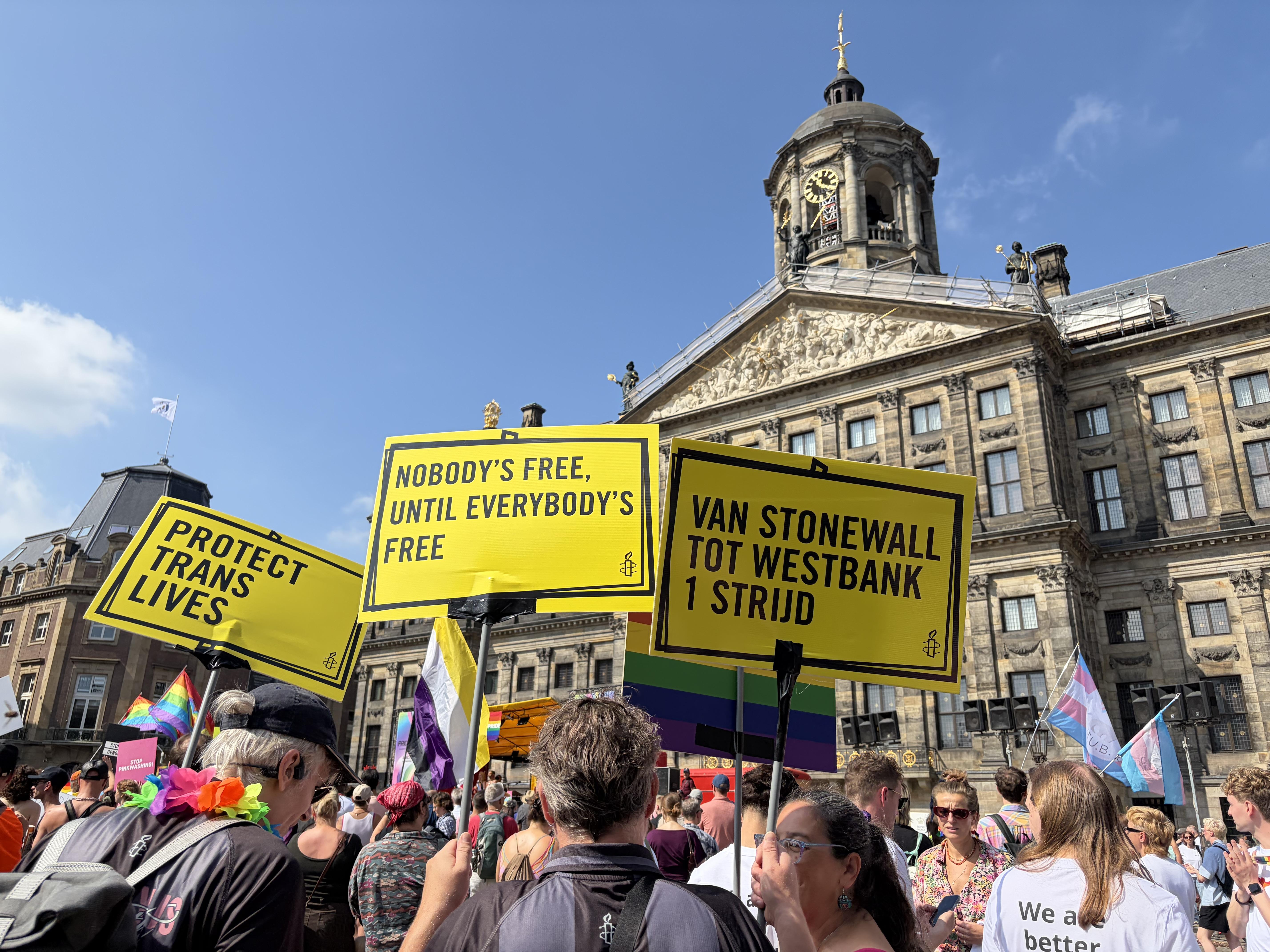 Protect Trans Lives, Nobody's Free Until Everybody's Free signs in Dams Square Amsterdam