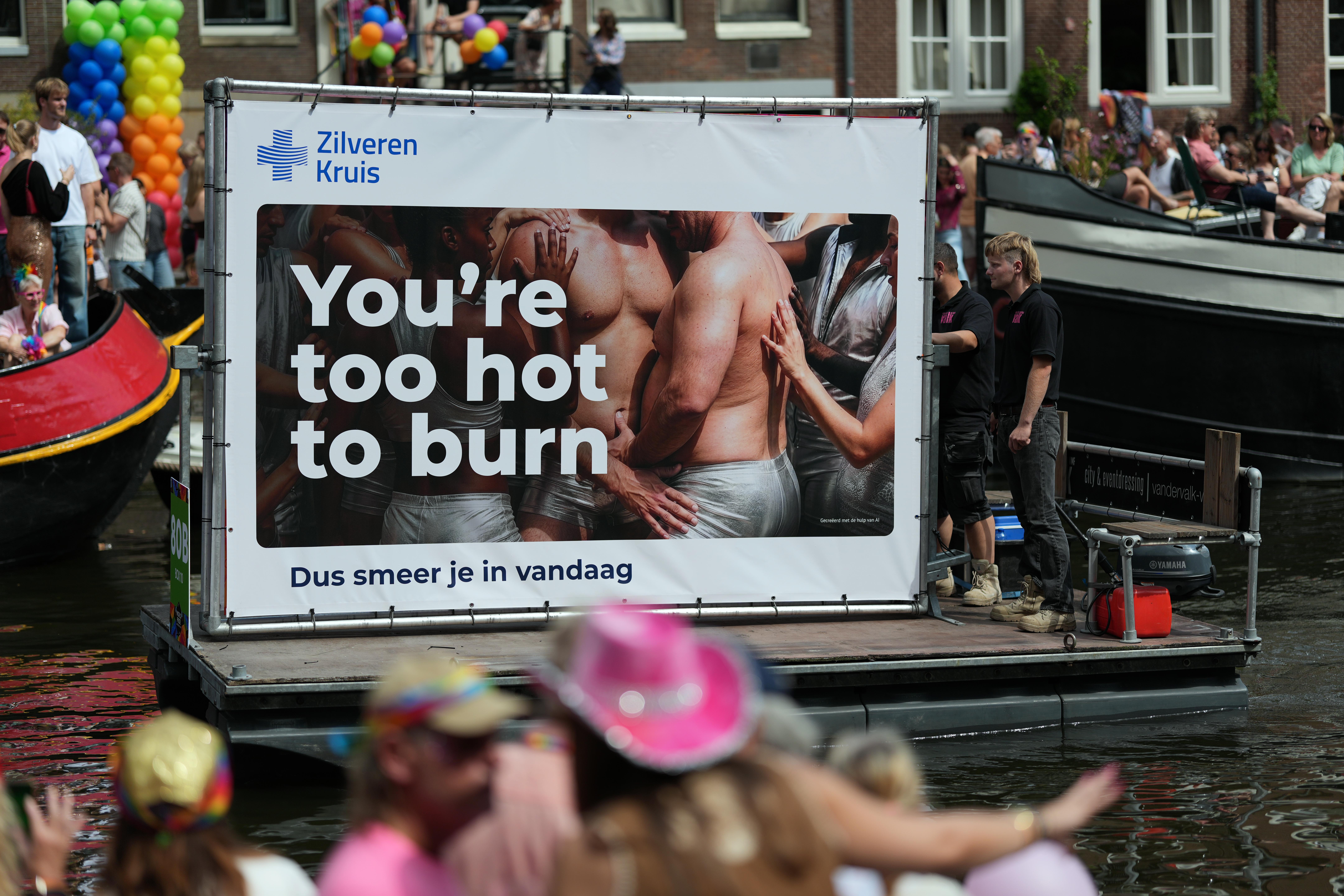 a Silver Cross (health care insurance provider in the Netherlands) advertisement saying "you're too hot to burn", on a small dingy floating down Canal Pride in Amsterdam