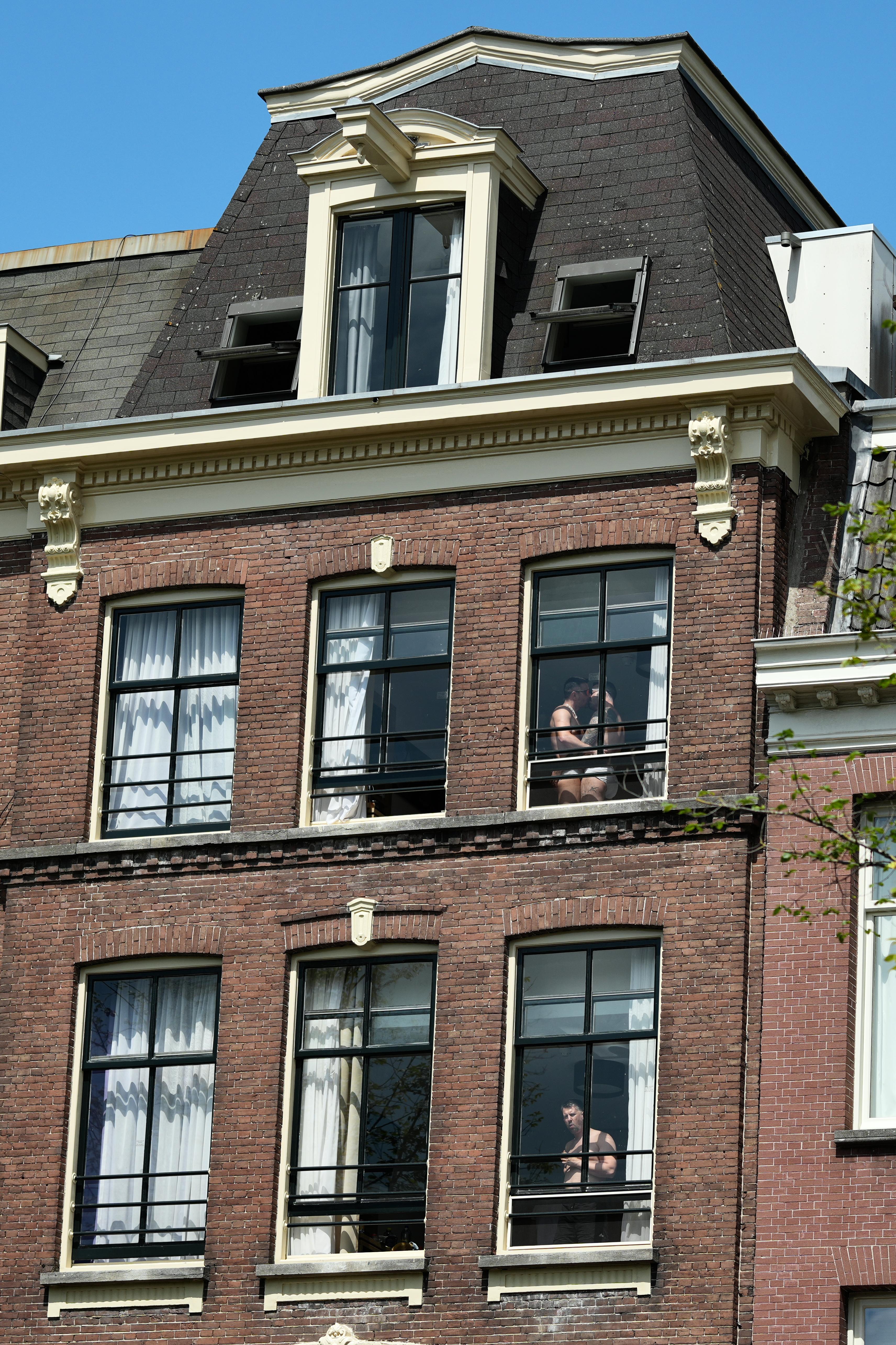 residents in their Dutch apartments enjoying Canal Pride in Amsterdam