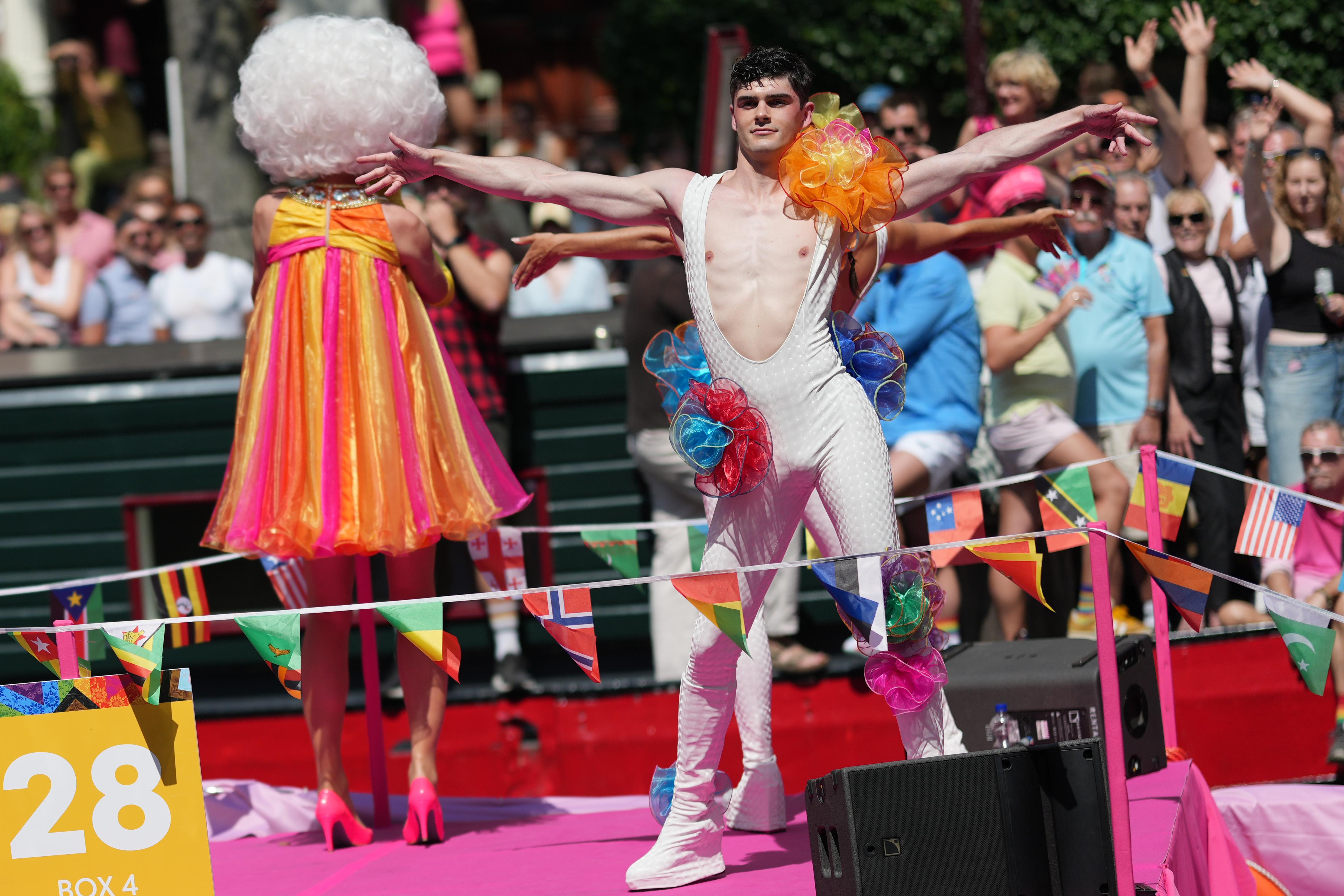a pair of dancers dance on boat 28 at Canal Pride in Amsterdam, with many people blurred out in the background